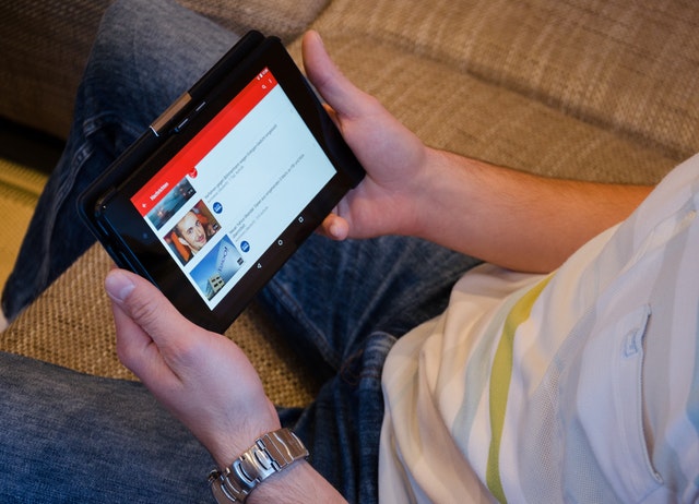 mužské ruky držia tablet, pozerať Youtube