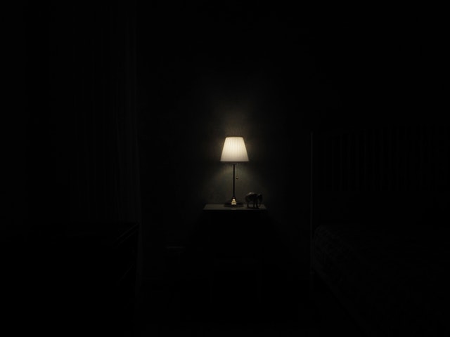 Zasvietená malá lampa v tmavej miestnosti.jpg