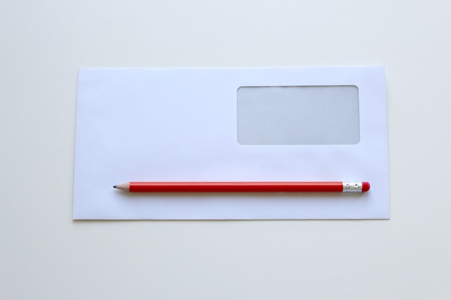 Biela obálka s fóliou a červené pero.jpg